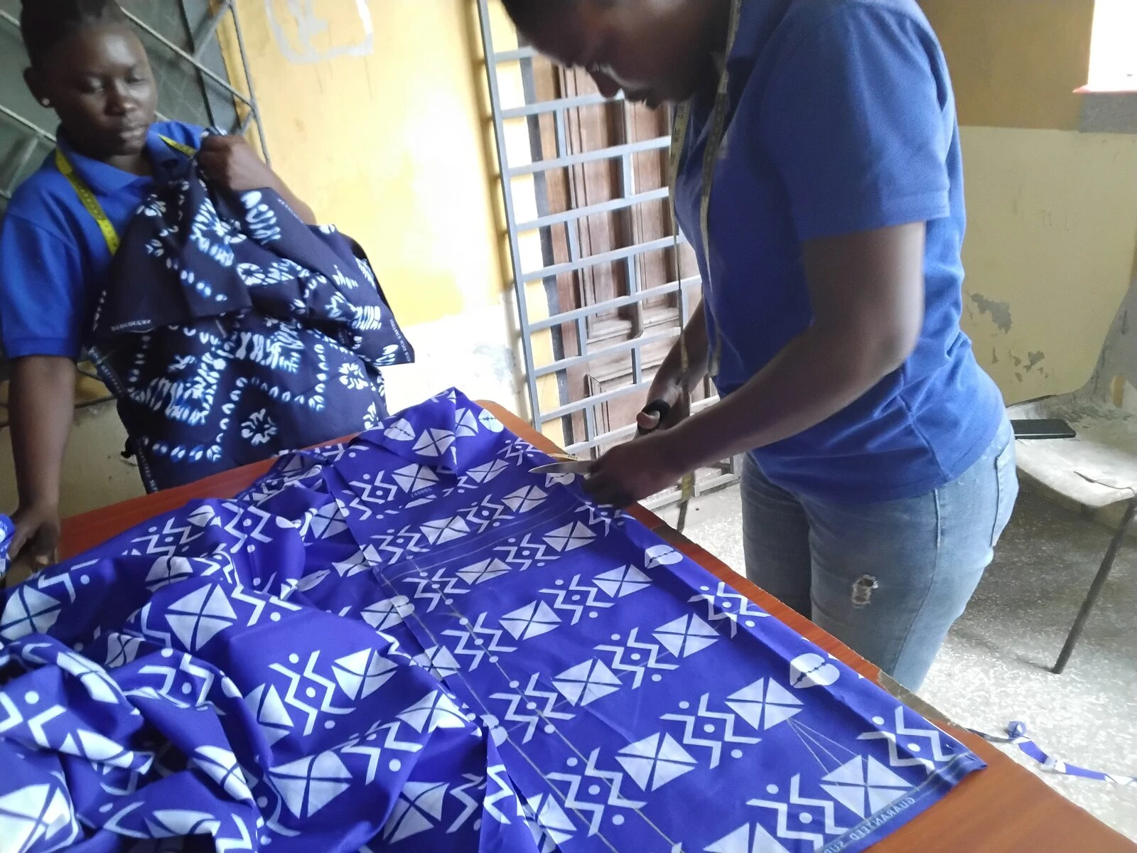 Student measuring and cutting fabric
